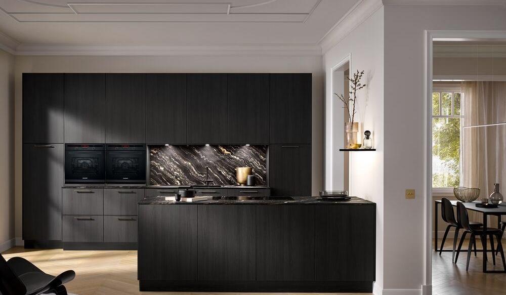 Küchenzeile Feineiche schwarz mit Nischenrückwand in Marmoroptik plus Kochinsel in Altbauwohnung